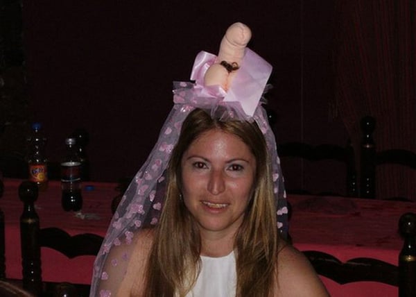 A woman wearing a wedding veil with a dummy in it, expressing