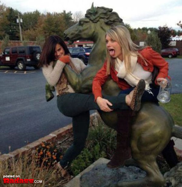 Two women are playing with a statue of a horse, but there's an undercurrent of