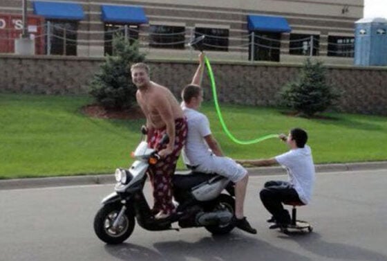 A group of people on a motorcycle, a little drunk, with a green hose.