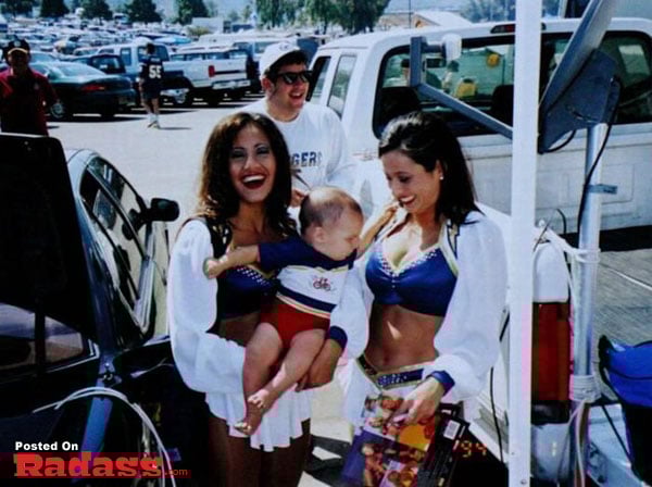 Three cheerleaders holding a baby in front of a car, showcasing the widespread popularity.