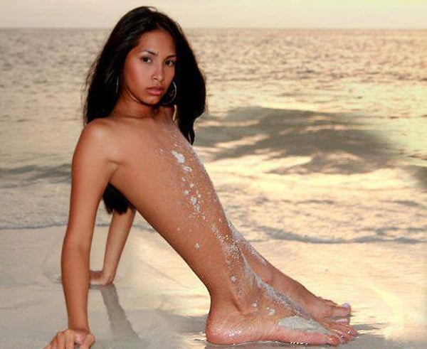 A young woman lounging on the beach.