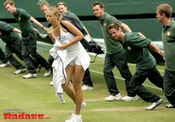 A tennis player is walking on a tennis court.