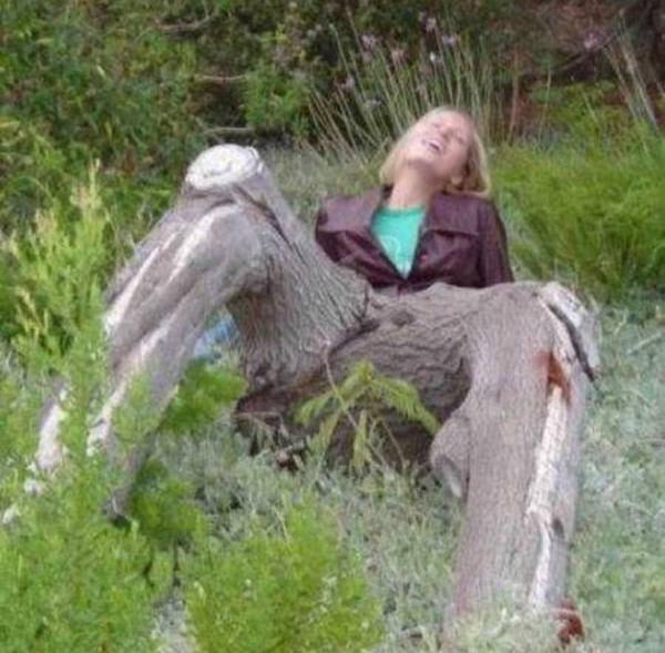 A woman resting on a tree stump.