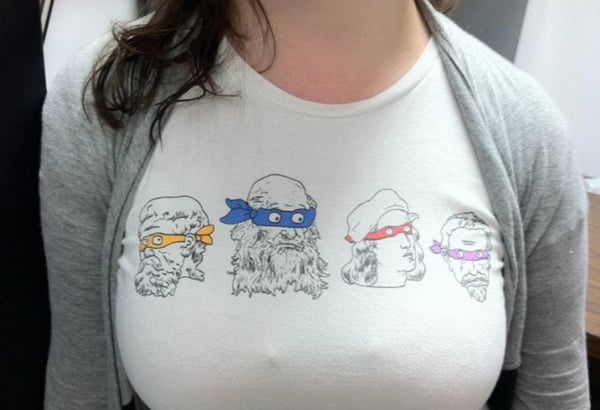 A woman wearing a t-shirt with four ninjas on it, representing