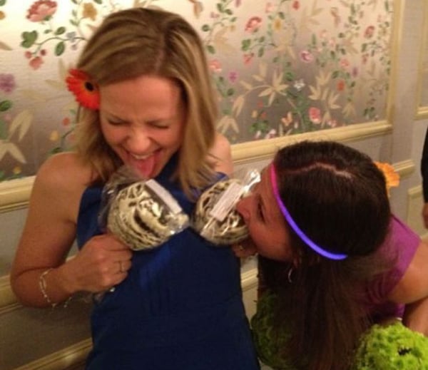 Two women kissing each other in front of a group of people, expressing their love and solidarity.