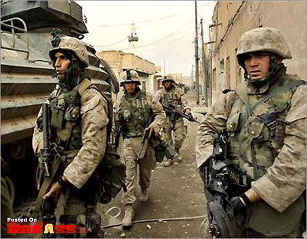 A group of American heroes are walking down a street with a tank.