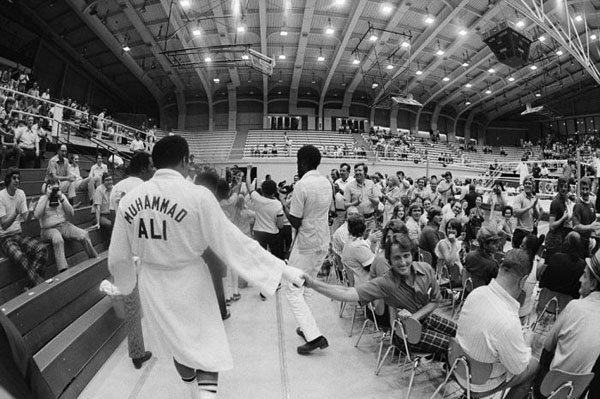 A black and white photo of a crowd in a gymnasium during