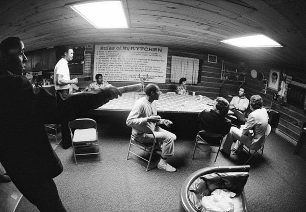 A room filled with people sitting around a table.