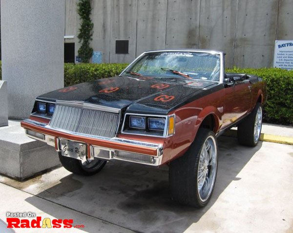 A red and black car parked in front of a building, making a bold entrance.