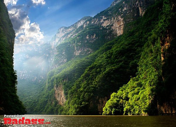 A river flows through a canyon with trees in the background, inviting you to leave all your worries behind and escape to this tranquil oasis.