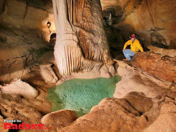 A man exploring a dimly-lit cave.