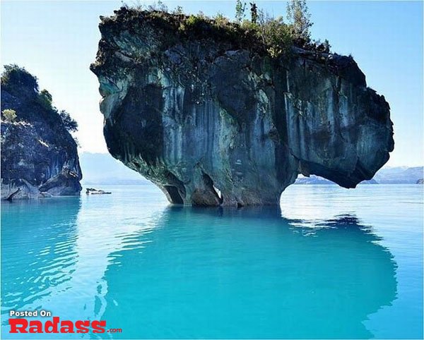 A boat near a rock formation in the water.