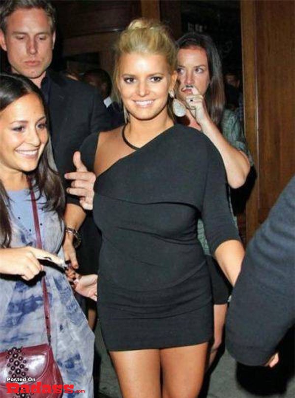 A woman in a black dress photobombs another woman walking by her, adding a touch of celebrity style.