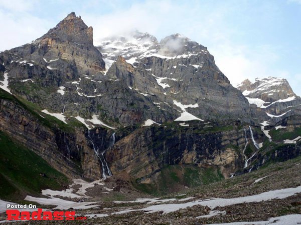 A secluded mountain range with a mesmerizing waterfall, offering an escape from civilization.