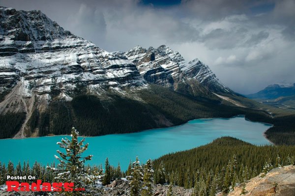 Escape to a serene blue lake nestled amidst majestic snow-capped mountains.