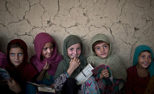 A group of girls are sitting in front of a wall, taking plenty of cool pics to brighten your Saturday.