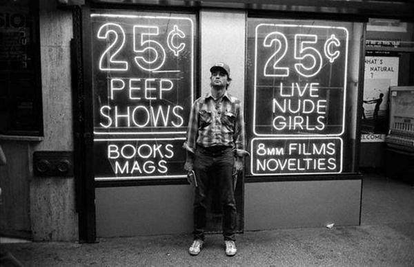 A man posing in front of a vibrant neon sign for plenty of cool pics to brighten your day.