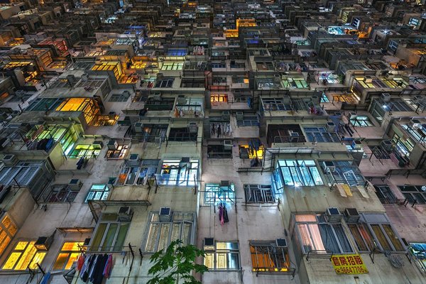 A building with plenty of windows illuminating the night.