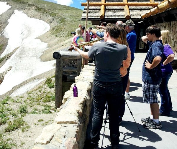 A group of hipsters standing on a ledge.