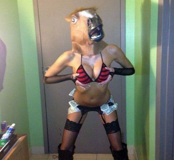 A woman wearing a horse mask in a bathroom.