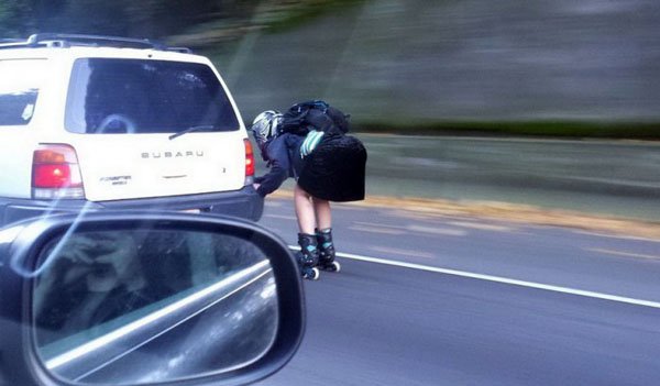 A person on a skateboard on the side of the road.