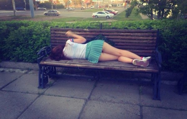 A woman is sleeping on a bench.