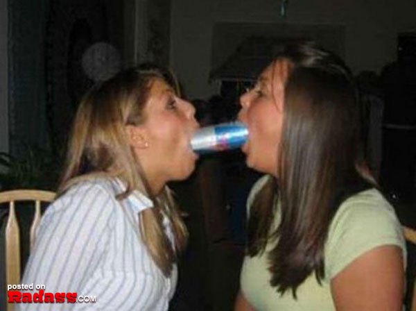 Two women drinking from a can of beer and jokingly saying