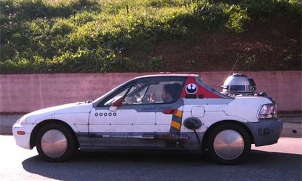 A white car adorned with a Star Wars sticker, representing WTF Cars.
