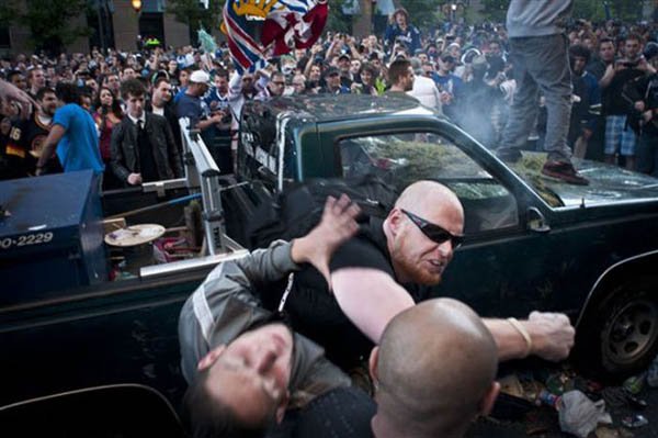 A group of people in a truck with a man in the back face plants.