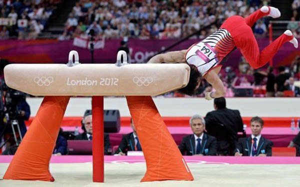 A gymnast is doing a routine on the balance beam and face plants.
