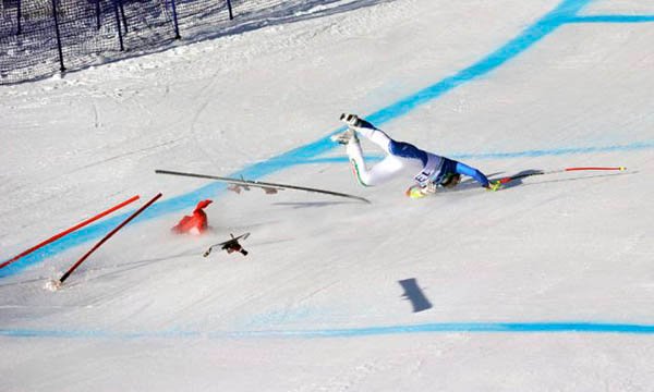 A skier is face planting while falling down a slope.