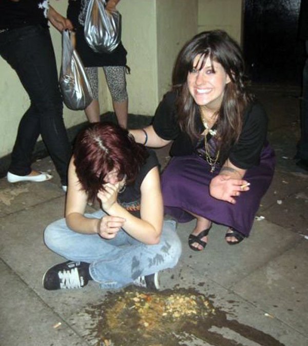 A woman kneeling on the ground next to a woman and saying