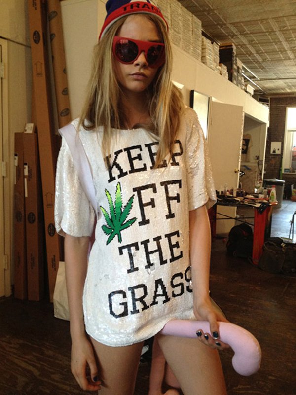 A woman wearing sunglasses and a t shirt with the words keep off the grass. I Would Date You But... she's not interested.