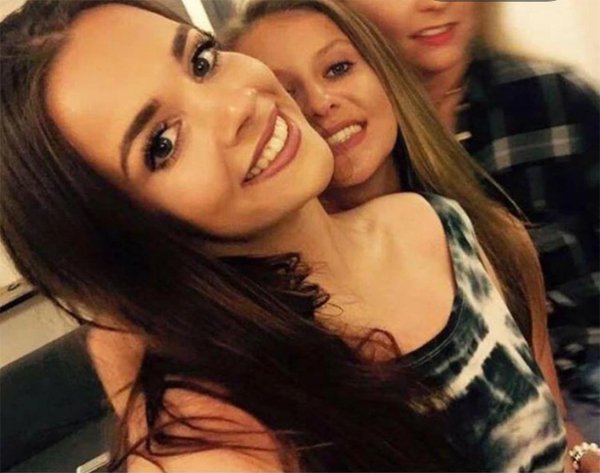 Two college graduates use Tinder as a resource to find job opportunities, while posing for a photo together.