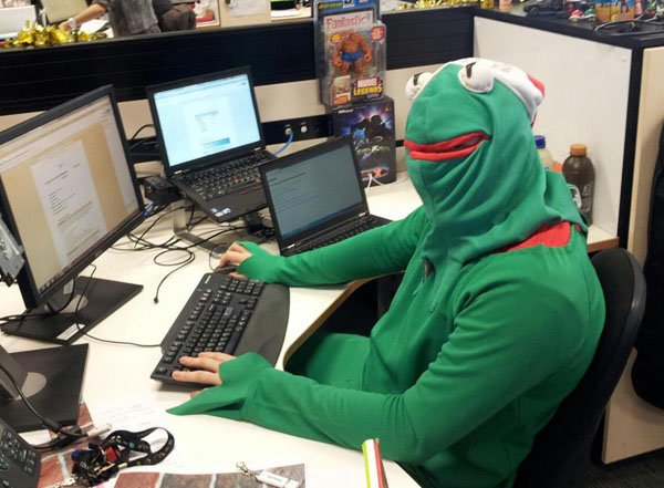 A man donning a green frog costume with a smile.