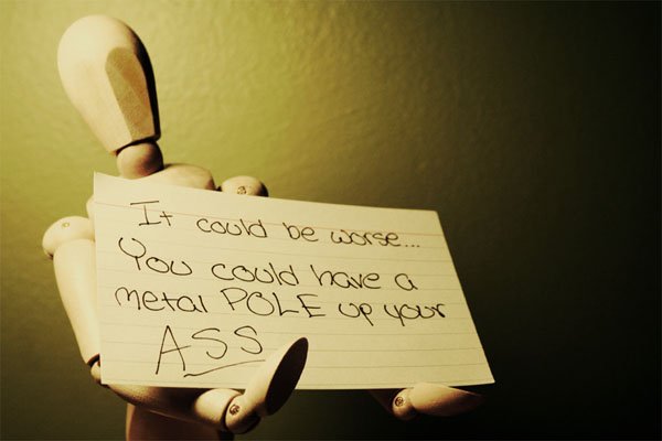 A mannequin holding a note that says if you could Smile, things could be worse.