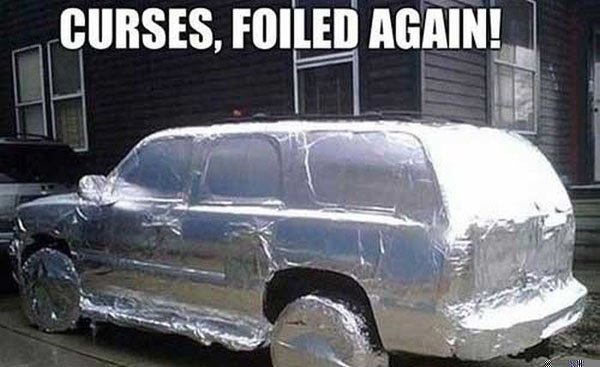 A car covered in foil with the words curses and trolls.
