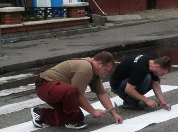 Two men observing a fish tank.