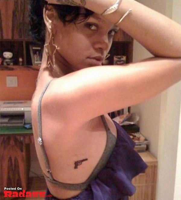 A woman adorned with a gun tattoo on her back is prepared for life's challenges.