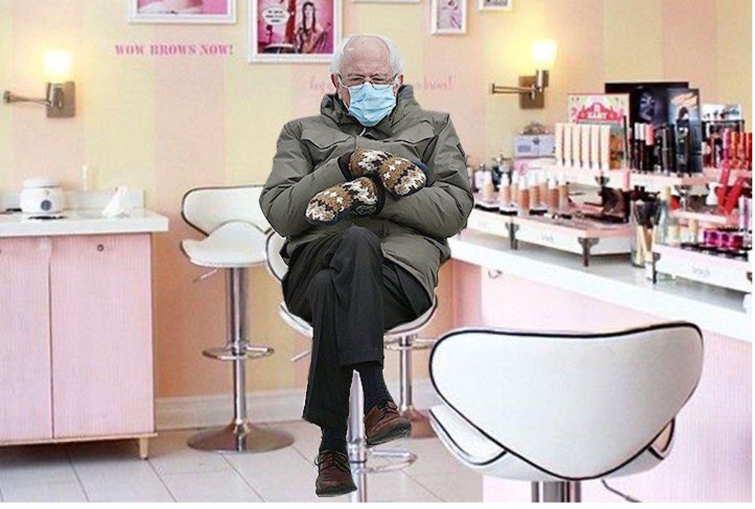 A man wearing a face mask sitting on a chair in a beauty salon while browsing Bernie Sanders Inauguration Memes.
