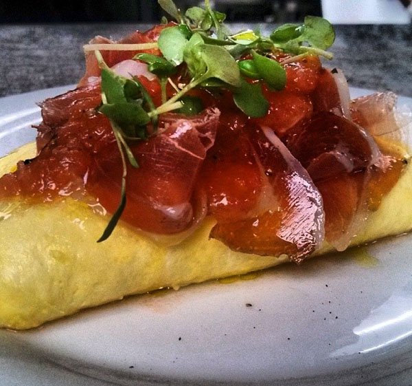 A plate with a mouthwatering omelet on top of it, warning: food porn ahead!