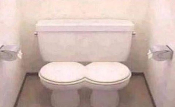 A bathroom with two toilets that can't stop the internet.