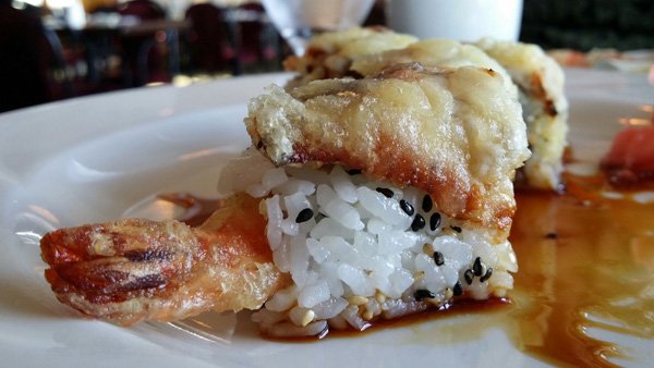 A visually enticing plate of sushi with rice and sauce, perfect for food porn lovers.