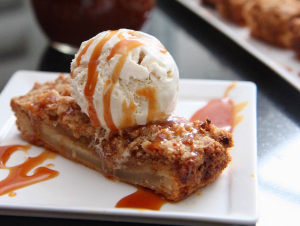 A tempting slice of apple pie indulged with ice cream and caramel sauce – food porn at its finest.