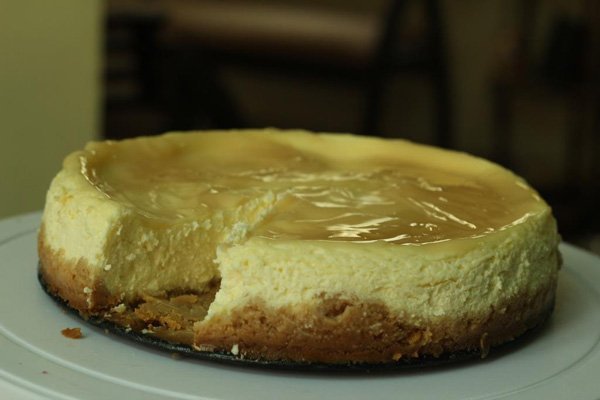 A tempting cheesecake featuring a tantalizing slice.
