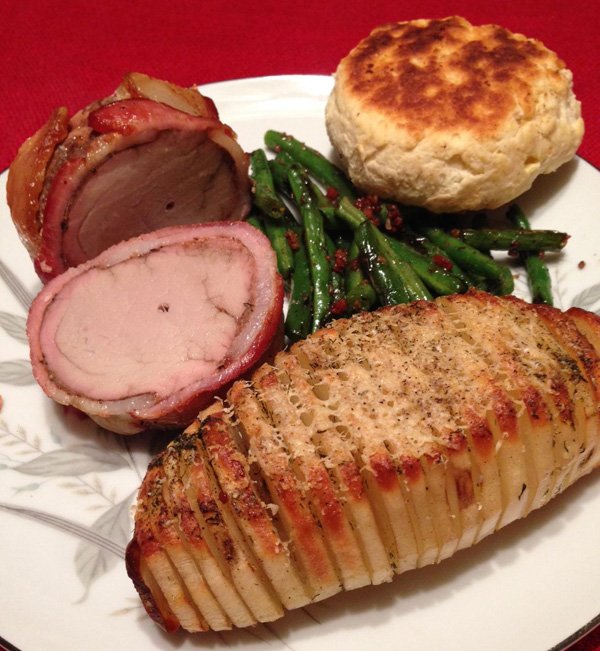 A mouthwatering photo of delicious roasted pork, green beans, and biscuits that will satisfy any food porn lover.