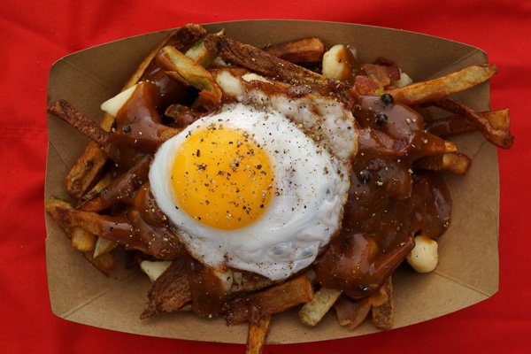 A mouthwatering plate of french fries topped with a savory fried egg.