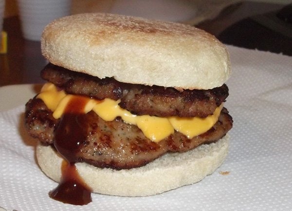 A mouthwatering food porn - a cheesy and saucy hamburger served on a napkin.