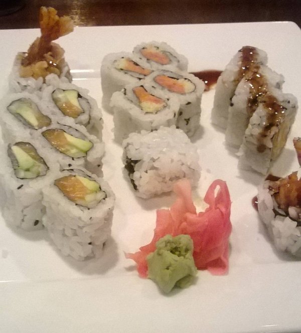 A plate of stunning food porn-worthy sushi topped with a variety of tantalizing ingredients.