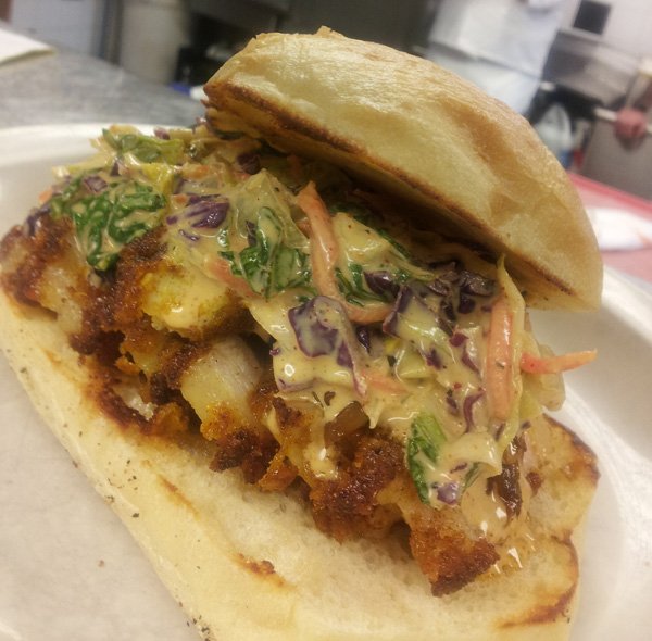 A mouthwatering sandwich on a pristine white plate.